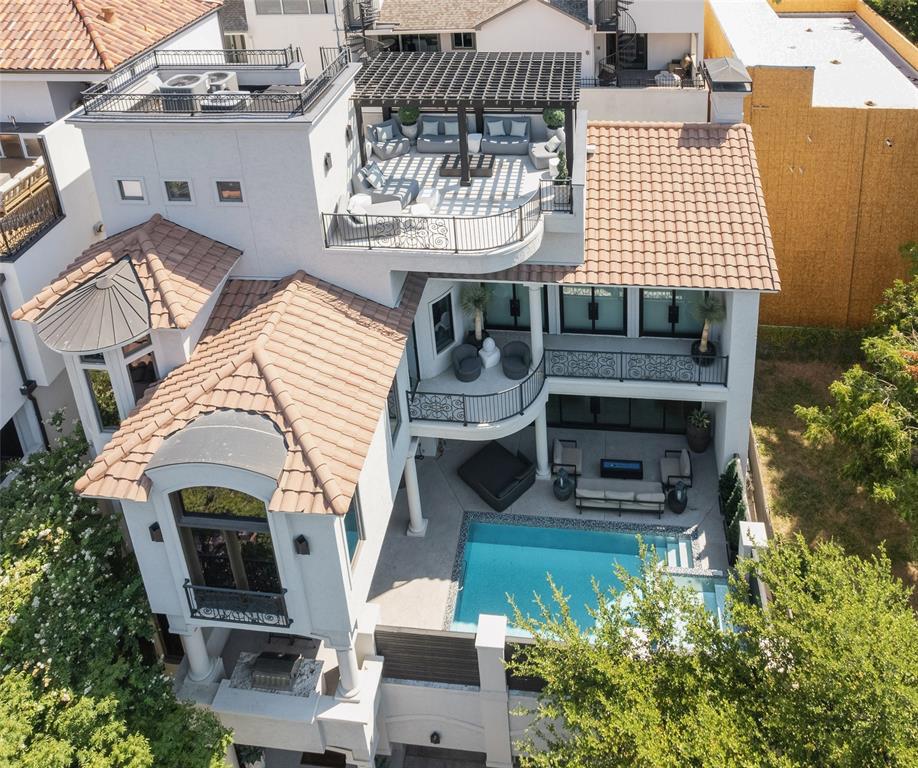 an aerial view of a house with balcony and outdoor seating