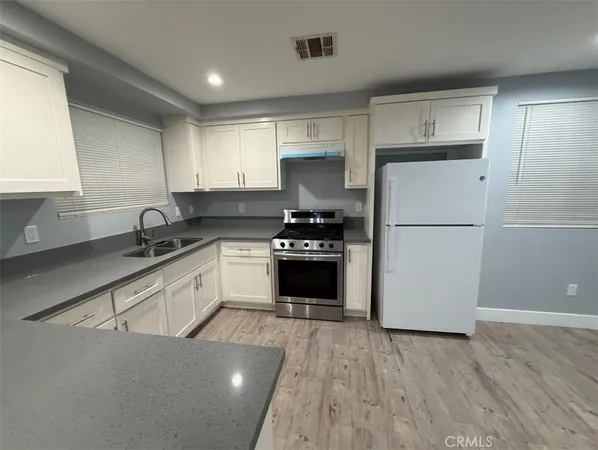 a bathroom with a granite countertop sink a toilet and a mirror