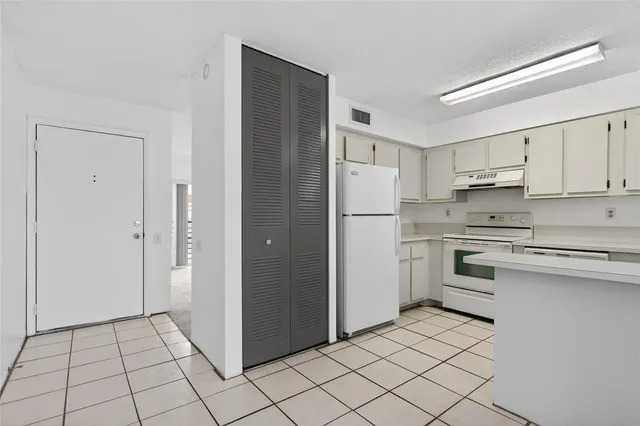 a kitchen with white cabinets and white appliances
