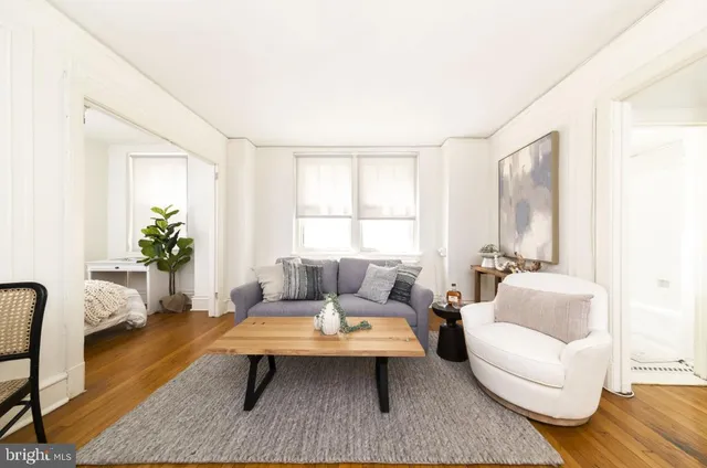 a living room with furniture wooden floor and a window