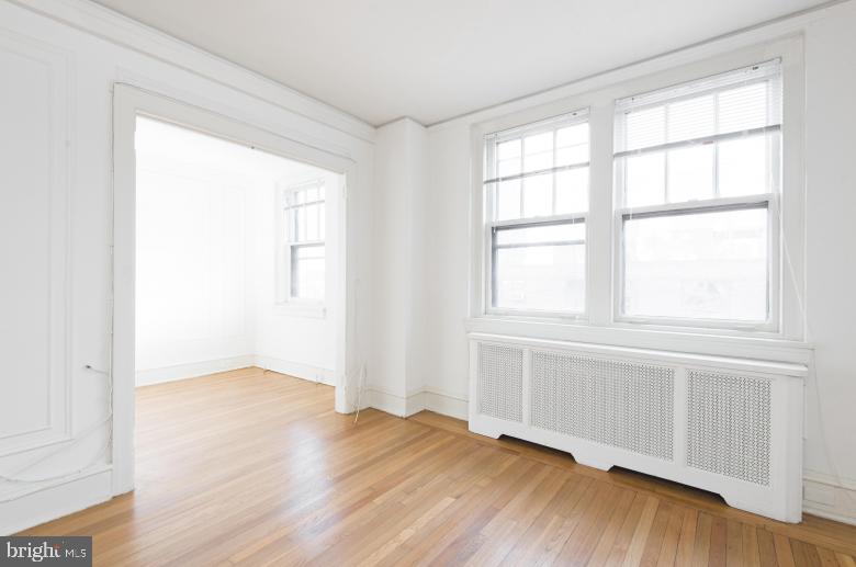 2100-2 Walnut Street, Unit 3E Philadelphia, PA 19103 - Photo 30 of 38 an empty room with wooden floor and windows