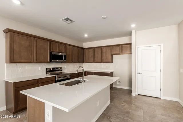 a kitchen that has a sink a stove and refrigerator