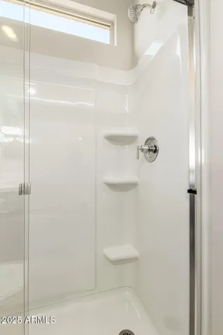 a bathroom with a sink a toilet a mirror and shower
