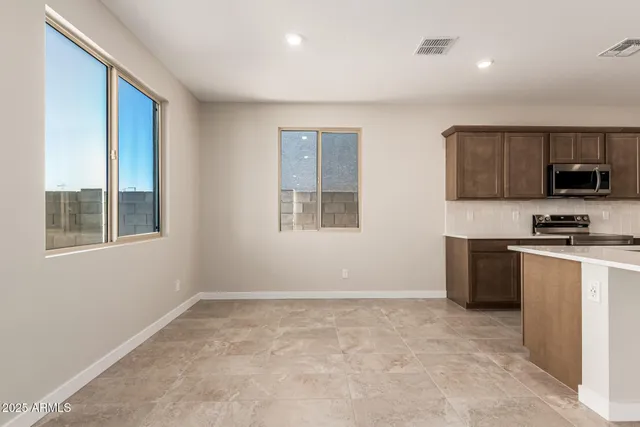 a kitchen with a refrigerator and a stove top oven