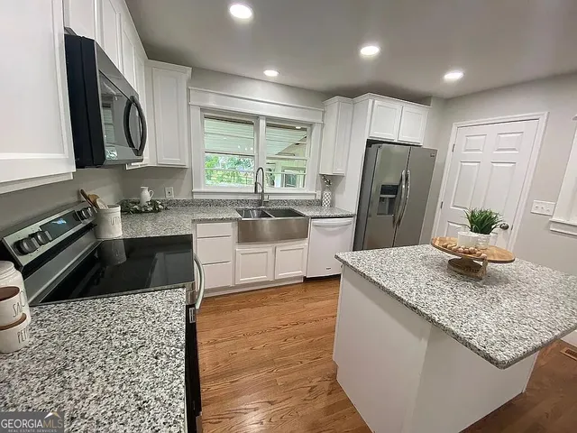 a kitchen with stainless steel appliances granite countertop a sink stove and refrigerator