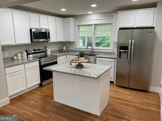 a kitchen with stainless steel appliances granite countertop a refrigerator stove microwave and sink