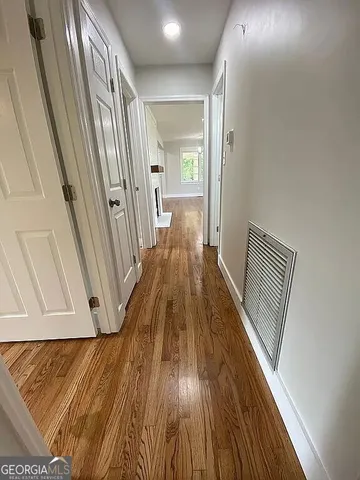 a view of a hallway view with wooden floor and staircase