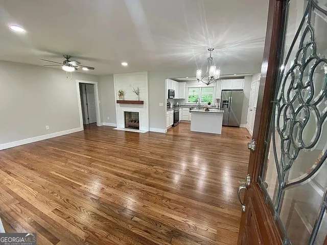a view of a hallway with furniture and chandelier