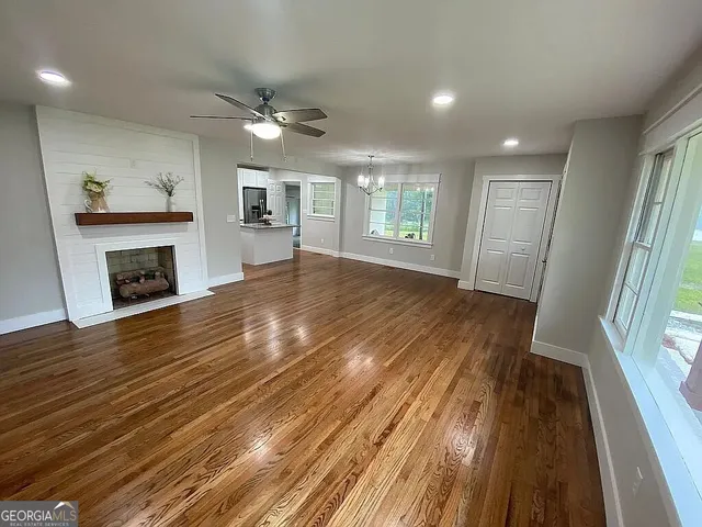 a view of empty room with wooden floor and fireplace