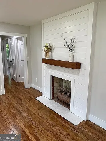 a living room with a fireplace and wooden floor
