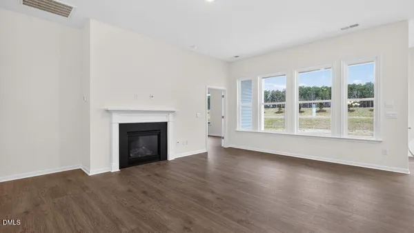 an empty room with window and wooden floor