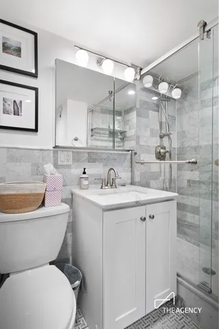 a bathroom with a granite countertop toilet sink and mirror