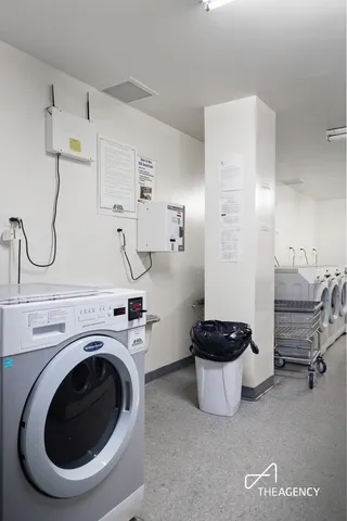 a room with a washing machine and a chair