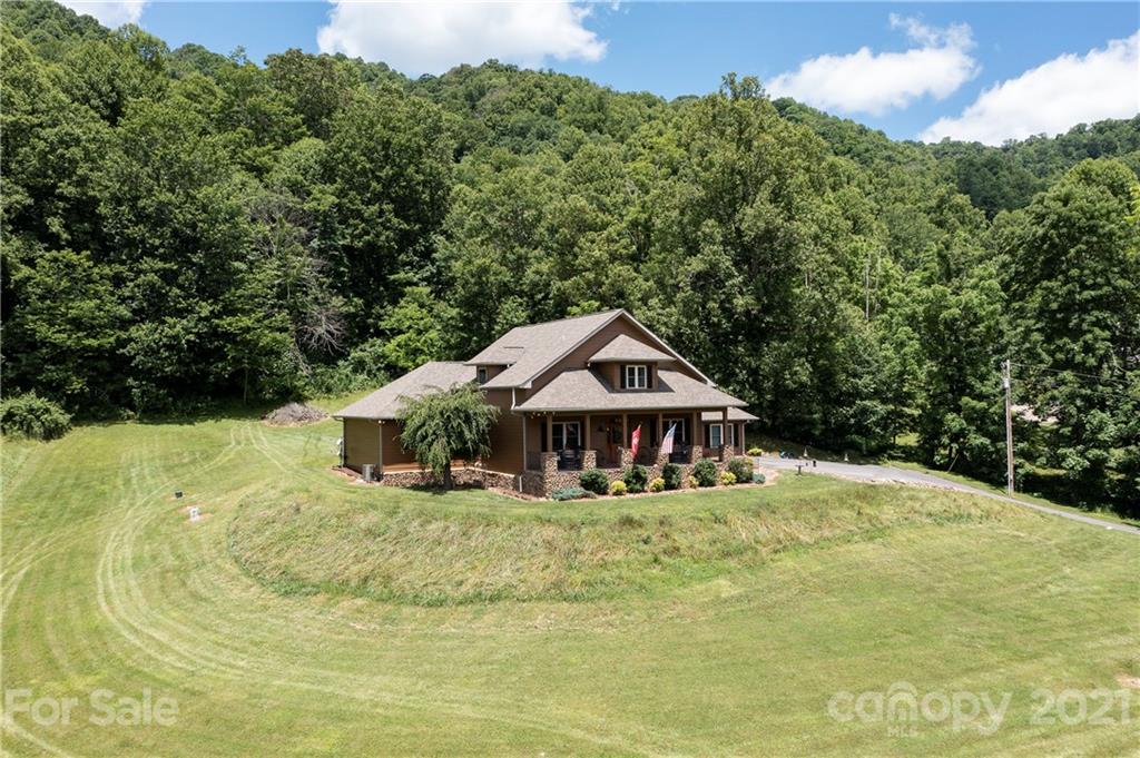 253 Benitez Way Clyde, NC 28721 - Photo 2 of 40 a white house covered with tall trees