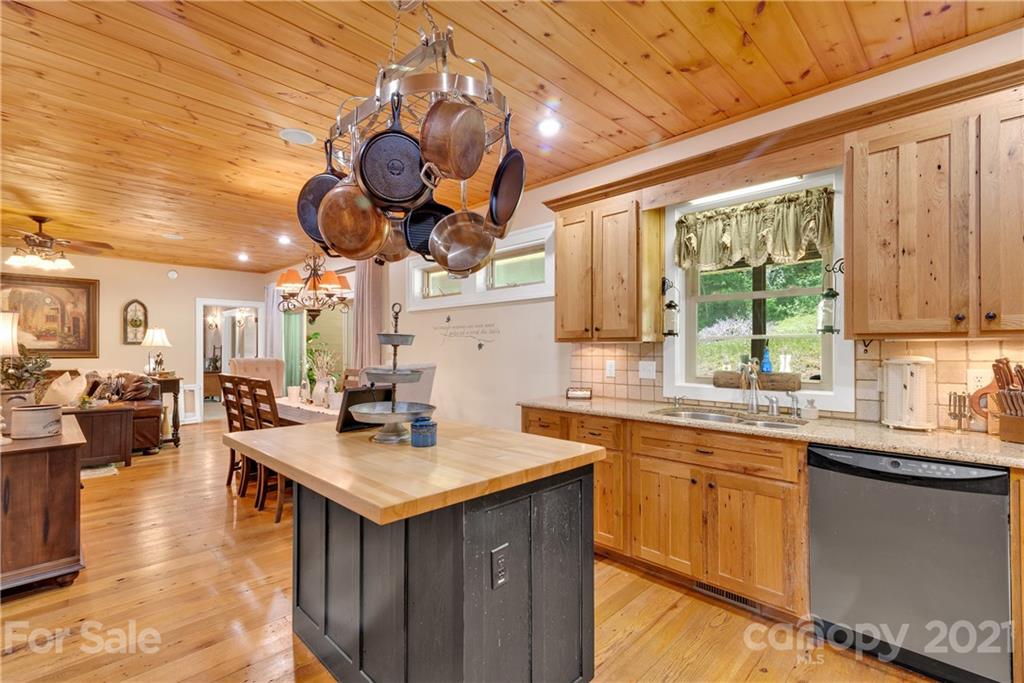 253 Benitez Way Clyde, NC 28721 - Photo 17 of 40 a kitchen with a stove cabinets and living room view