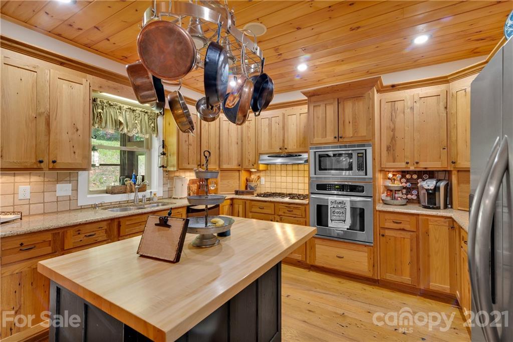 253 Benitez Way Clyde, NC 28721 - Photo 18 of 40 a kitchen with stainless steel appliances granite countertop a sink a stove and a refrigerator