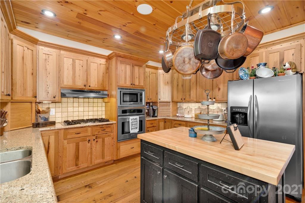 253 Benitez Way Clyde, NC 28721 - Photo 19 of 40 a kitchen with kitchen island granite countertop a sink a counter space appliances and cabinets