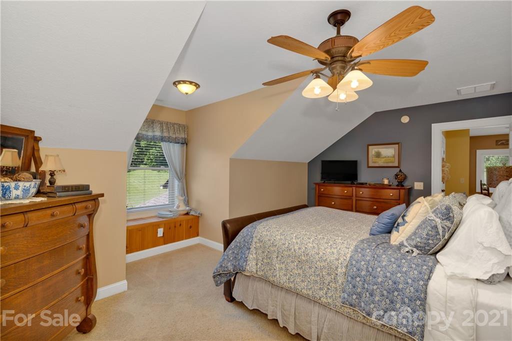 253 Benitez Way Clyde, NC 28721 - Photo 30 of 40 a bedroom with a bed and a chandelier