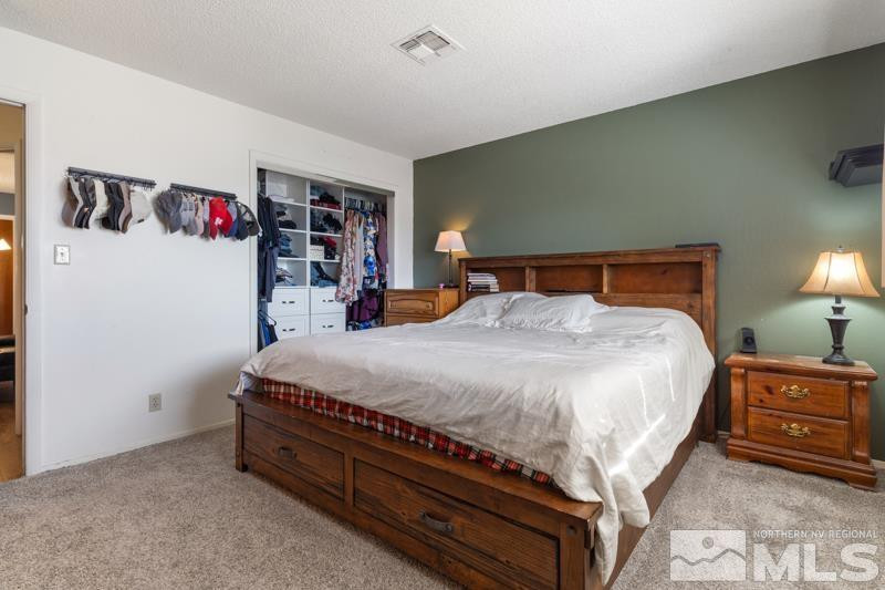 613 Ivy Street Carson City, NV 89703 - Photo 17 of 25 a bed sitting in a bedroom next to a lamp