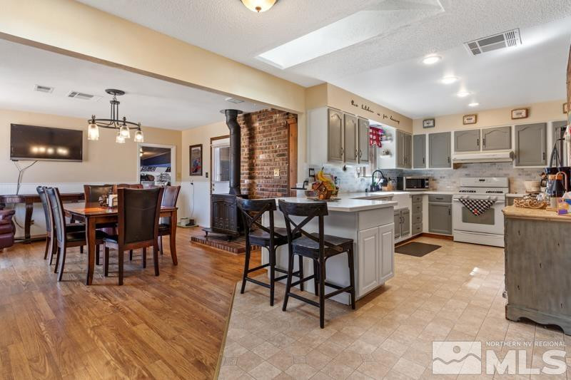 613 Ivy Street Carson City, NV 89703 - Photo 7 of 25 a kitchen with stainless steel appliances a dining table chairs and a refrigerator