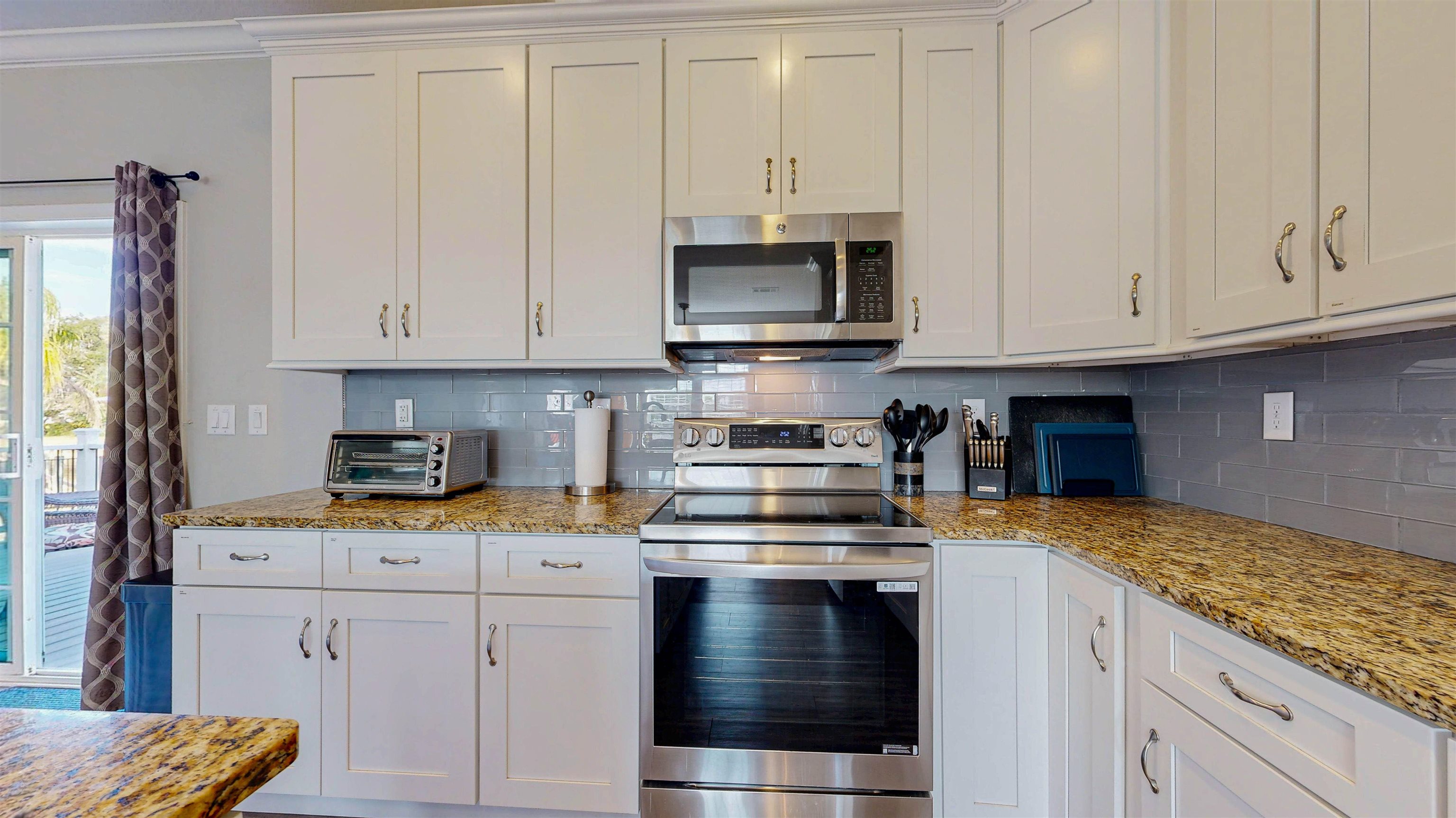 5910 Rio Royalle Road St. Augustine, FL 32080 - Photo 15 of 48 a kitchen with stainless steel appliances granite countertop a stove a sink and white cabinets