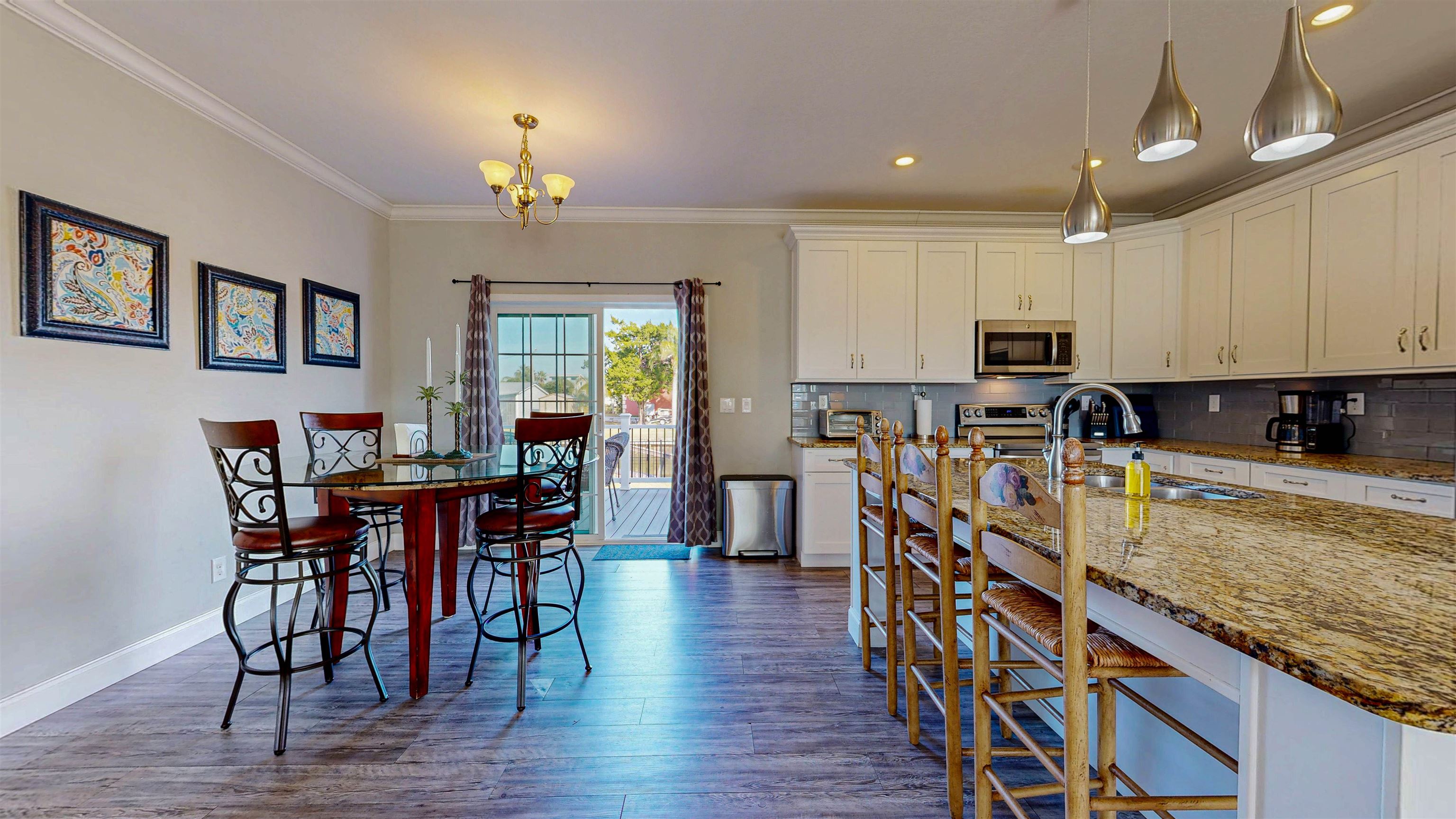 5910 Rio Royalle Road St. Augustine, FL 32080 - Photo 19 of 48 a kitchen with stainless steel appliances granite countertop a stove top oven a sink a dining table and chairs with wooden floor