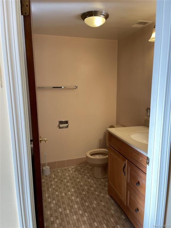 a bathroom with a granite countertop toilet and a sink