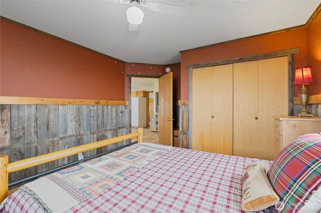 a bedroom with a bed and a lamp on dresser