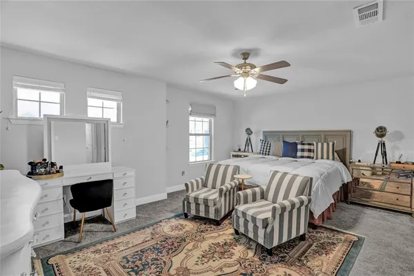 a bedroom with a bed a chandelier and a couch