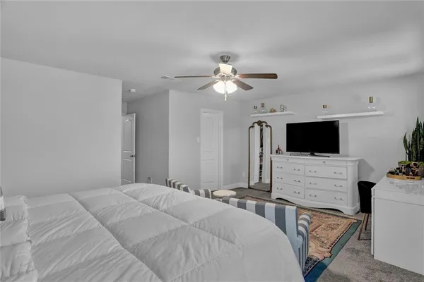 a bedroom with a bed a flat screen tv and a couch