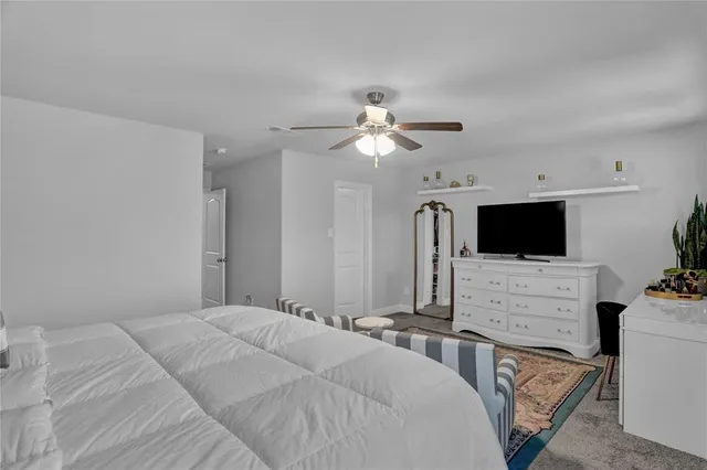 a bedroom with a bed a flat screen tv and a couch