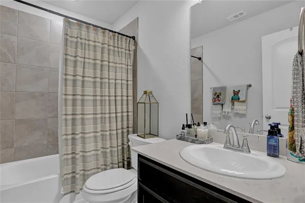 a bathroom with a sink a toilet a mirror and shower