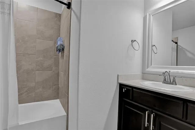 a bathroom with a granite countertop sink a mirror and shower