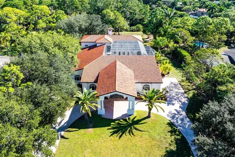 an aerial view of a house with swimming pool and garden space