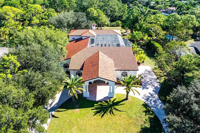 an aerial view of a house with swimming pool and garden space