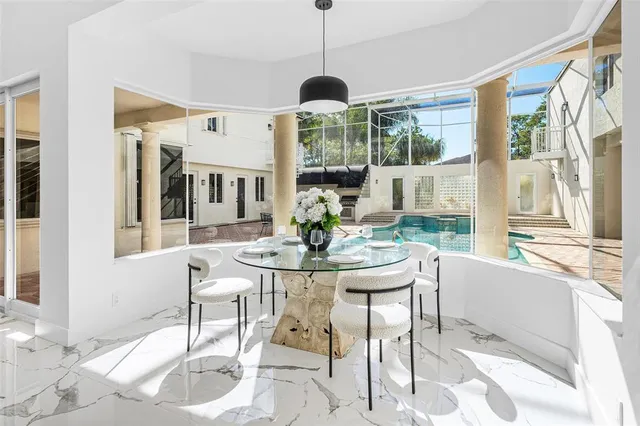 a dining room with furniture a chandelier and wooden floor