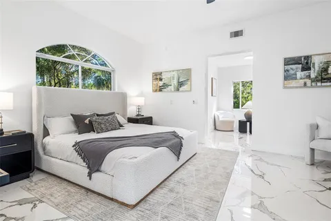 a bedroom with a large bed and a window