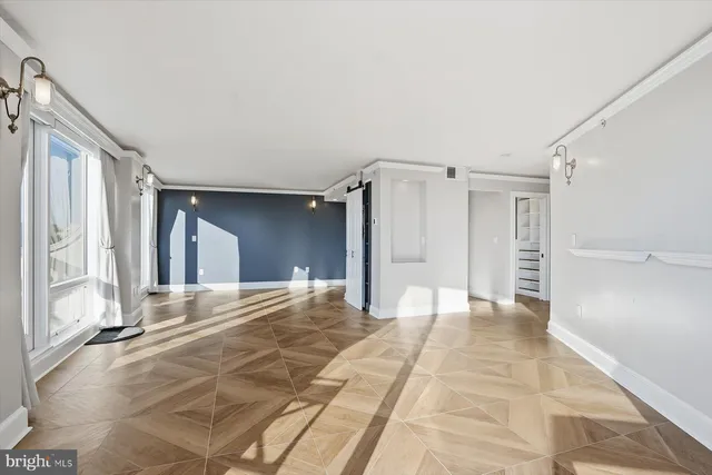 a view of a hallway with wooden floor and cabinet