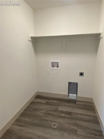 an empty room with chandelier fan and windows