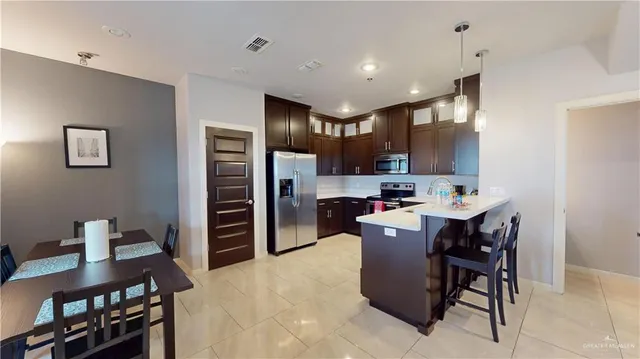 a kitchen with a table chairs refrigerator and microwave