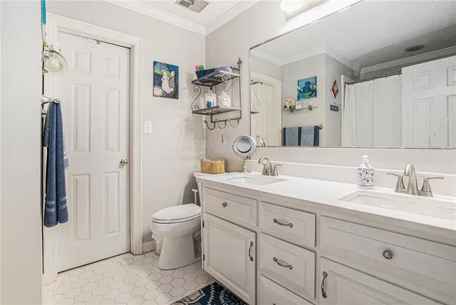a bathroom with a granite countertop sink vanity mirror and toilet