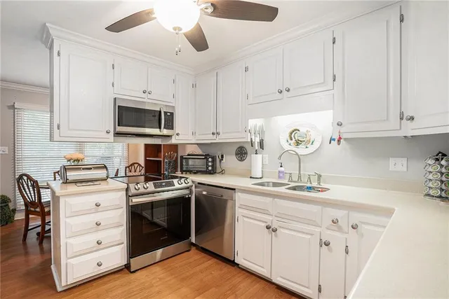 a kitchen with granite countertop white cabinets and stainless steel appliances