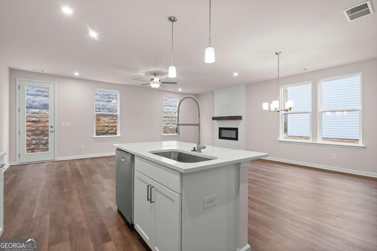 706 Smokey Quartz Way Kennesaw, GA 30144 - Photo 15 of 35 a kitchen with a sink stove and wooden floor