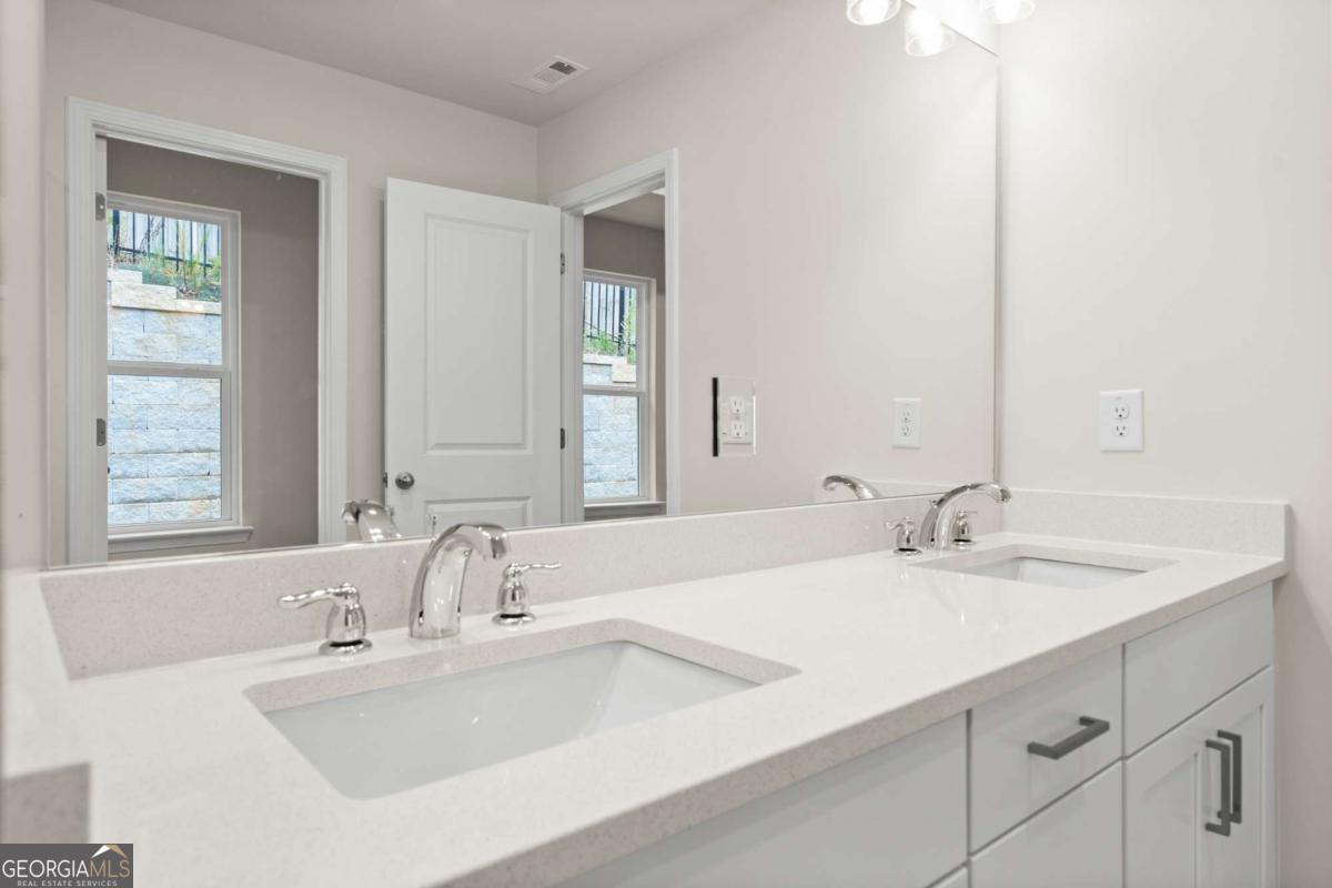 706 Smokey Quartz Way Kennesaw, GA 30144 - Photo 26 of 35 a bathroom with double sink and a mirror