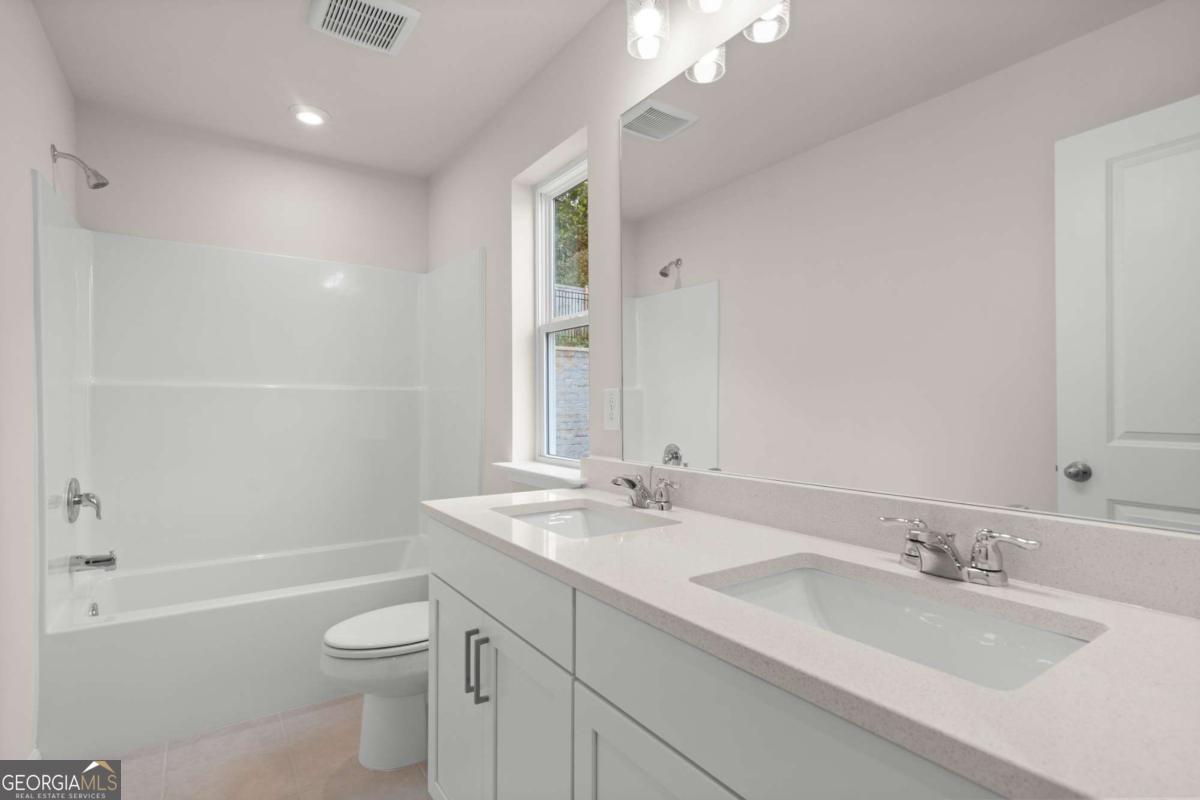 706 Smokey Quartz Way Kennesaw, GA 30144 - Photo 31 of 35 a bathroom with a granite countertop sink a toilet and bathtub
