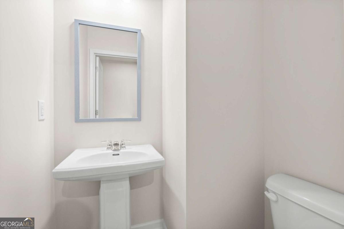 706 Smokey Quartz Way Kennesaw, GA 30144 - Photo 5 of 35 a bathroom with a sink a toilet and mirror