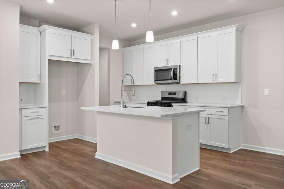 706 Smokey Quartz Way Kennesaw, GA 30144 - Photo 8 of 35 a kitchen with cabinets stainless steel appliances a sink and wooden floor