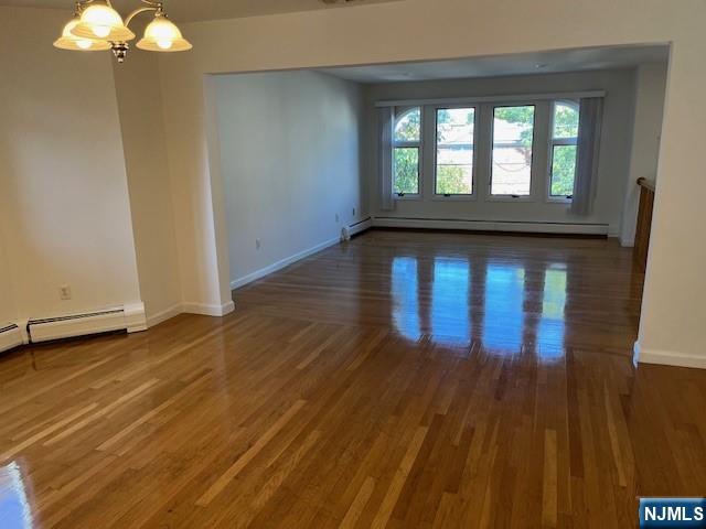 2440 B 3rd Street Fort Lee, NJ 07024 - Photo 5 of 16 a view of an empty room with wooden floor and a window