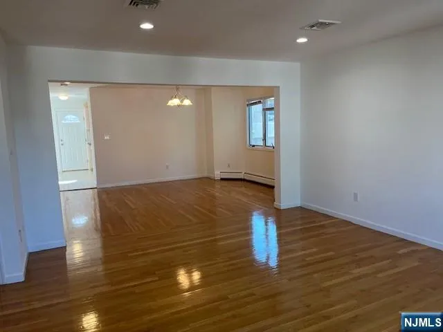 a view of empty room with wooden floor