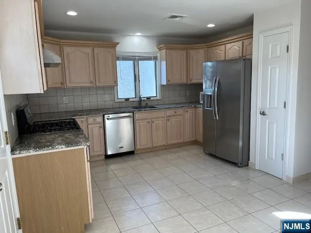 a kitchen with stainless steel appliances granite countertop a refrigerator sink and cabinets